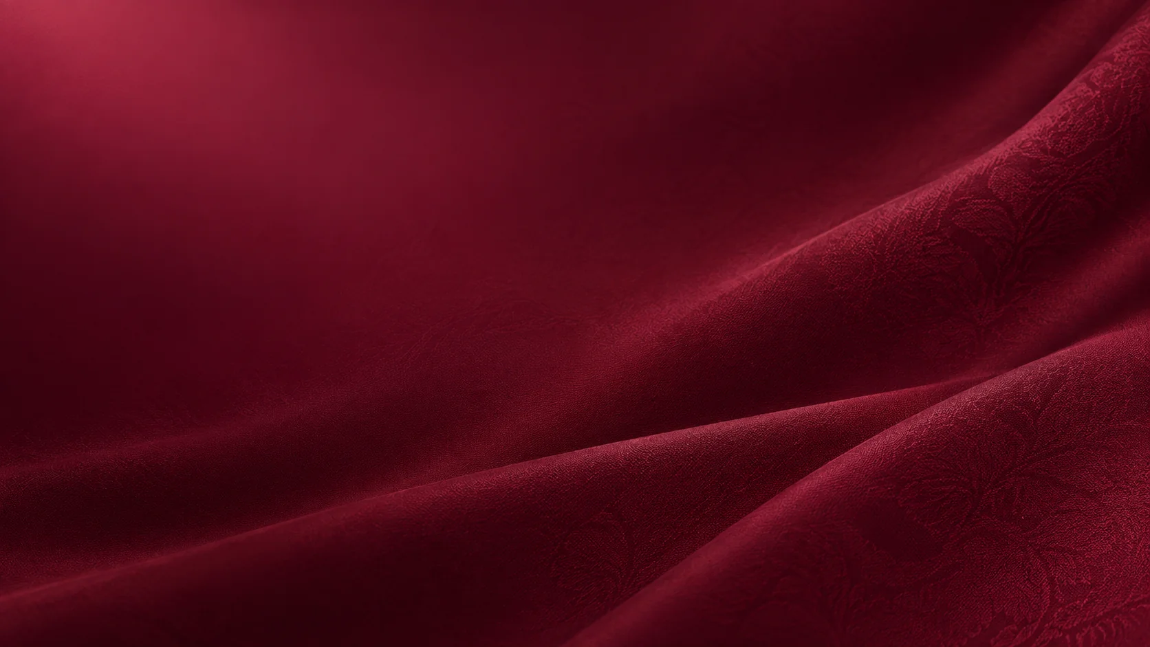 Burgundy fabric folds with varied woven textures.